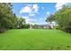 Expansive backyard showcasing lush lawn and landscaping with a screened pool enclosure in the background at 6233 Rydal Ct, Windermere, FL 34786
