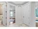 Elegant bathroom hallway featuring neutral tile flooring, a door to a bedroom, and a large archway at 6233 Rydal Ct, Windermere, FL 34786