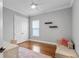 This bedroom features hardwood floors, a ceiling fan, and natural light at 6233 Rydal Ct, Windermere, FL 34786