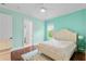 A well-lit bedroom with turquoise walls, a white bed, and hardwood floors at 6233 Rydal Ct, Windermere, FL 34786