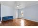 A well-lit blue bedroom featuring hardwood floors, a ceiling fan, and a window at 6233 Rydal Ct, Windermere, FL 34786