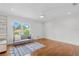 Bright bedroom featuring hardwood floors, ceiling fan, and a large window overlooking lush greenery at 6233 Rydal Ct, Windermere, FL 34786