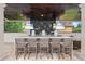 Outdoor bar with granite countertops, pendant lighting, televisions, and seating for casual entertaining at 6233 Rydal Ct, Windermere, FL 34786