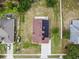An aerial view captures a home's roof with solar panels, a driveway, and a well-maintained lawn at 7243 Minippi Dr, Orlando, FL 32818