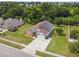 An aerial view of a single-story home with solar panels, a driveway, and a well-kept lawn at 7243 Minippi Dr, Orlando, FL 32818