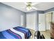 Bedroom with a ceiling fan, tiled floors, and a closet with white folding doors at 7243 Minippi Dr, Orlando, FL 32818