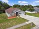 Inviting home featuring a lush lawn, mature trees, and a long driveway at 7243 Minippi Dr, Orlando, FL 32818