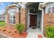 Inviting entryway with brick accents, a well-manicured garden bed and a stylish front door at 7243 Minippi Dr, Orlando, FL 32818