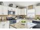 Bright kitchen with granite countertops, tile backsplash, stainless steel appliances, and island at 7243 Minippi Dr, Orlando, FL 32818