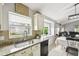 Bright kitchen featuring granite countertops, stainless steel sink, adjacent to breakfast nook and living area at 7243 Minippi Dr, Orlando, FL 32818
