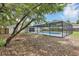 Backyard with mature trees featuring a screened-in pool, creating a serene outdoor setting at 822 Glen Arden Way, Altamonte Springs, FL 32701