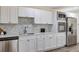 Elegant kitchen with stainless steel appliances, white cabinets, marble backsplash, and modern fixtures at 822 Glen Arden Way, Altamonte Springs, FL 32701