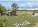The backyard includes a wood fence, a small storage shed, and is primarily grass-covered at 8812 Oakwood Dr, Lake Wales, FL 33898