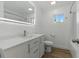 Bright bathroom featuring a sleek vanity, modern mirror, and wood-look flooring at 8812 Oakwood Dr, Lake Wales, FL 33898