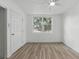 Bedroom features hardwood floors, a ceiling fan, and a bright window at 8812 Oakwood Dr, Lake Wales, FL 33898
