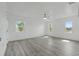 Spacious bedroom featuring hardwood floors and three windows allowing for ample natural light at 8812 Oakwood Dr, Lake Wales, FL 33898