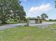 A home features a stone facade, an attached garage, a circular driveway, and beautiful landscaping at 8812 Oakwood Dr, Lake Wales, FL 33898