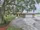 Charming single-story home with a stone-accented garage and a sprawling tree in the front yard at 8812 Oakwood Dr, Lake Wales, FL 33898