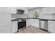 Contemporary kitchen featuring stainless steel appliances, light wood flooring, and crisp white cabinetry at 8812 Oakwood Dr, Lake Wales, FL 33898