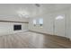 Bright living room featuring wood flooring, white walls, fireplace, and modern lighting at 8812 Oakwood Dr, Lake Wales, FL 33898