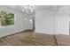 Bright living room featuring modern lighting, new flooring, and a large window at 8812 Oakwood Dr, Lake Wales, FL 33898