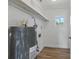 A utility room features a hot water tank, wood-look floors, shelving, and a window that lets in natural light at 8812 Oakwood Dr, Lake Wales, FL 33898
