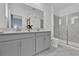 Modern bathroom with double vanity, gray cabinets, quartz countertops, and glass-enclosed shower at 9239 Sommerset Hills Dr, Davenport, FL 33896