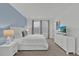 Bright bedroom features a plush bed, blue accent wall, and large windows with modern window treatments at 9239 Sommerset Hills Dr, Davenport, FL 33896