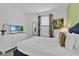 Bright bedroom features a comfortable bed, tropical wall art, and a flat-screen TV at 9239 Sommerset Hills Dr, Davenport, FL 33896