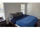 Cozy bedroom featuring a comfortable queen-size bed, natural light from the window, and hardwood floors at 9471 Comeau St, Gotha, FL 34734