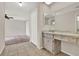 Well-lit vanity area adjacent to a bedroom, featuring tile flooring and countertop at 963 Beach Breeze Dr, Orlando, FL 32835