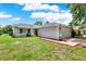 The home features a manicured lawn, driveway and two car garage at 963 Beach Breeze Dr, Orlando, FL 32835