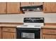Close up of a kitchen range with wood cabinets and an overhead vent at 963 Beach Breeze Dr, Orlando, FL 32835