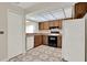 Bright kitchen features wood cabinets, black range and modern geometric tile floor at 963 Beach Breeze Dr, Orlando, FL 32835