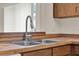 Close-up of a stainless kitchen sink with wood cabinets and modern faucet at 963 Beach Breeze Dr, Orlando, FL 32835