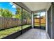 Cozy screened porch with tile flooring and views of the fenced backyard at 963 Beach Breeze Dr, Orlando, FL 32835