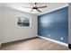 Bright bedroom with natural light, wood floors, and a blue accent wall exudes modern simplicity at 107 Laurel Oak Dr, Longwood, FL 32779
