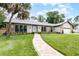 Inviting home featuring a manicured lawn, stone details, and a brick walkway leading to the entrance at 107 Laurel Oak Dr, Longwood, FL 32779