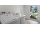 Well-lit laundry room with modern appliances, with a bright window and neighborhood view at 107 Laurel Oak Dr, Longwood, FL 32779