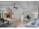 Bright living room featuring a stone fireplace, ceiling fan, vaulted ceilings, and hardwood floors at 107 Laurel Oak Dr, Longwood, FL 32779