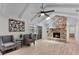 Open-concept living room with a stone fireplace, hardwood floors, ceiling fan, and sliding glass doors to the patio at 107 Laurel Oak Dr, Longwood, FL 32779