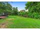 Expansive backyard featuring lush green grass and privacy landscaping with mature trees and an enclosed patio at 111 Main St, Windermere, FL 34786