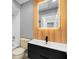 Bathroom featuring a light-up mirror, wood paneled wall, and black vanity at 111 Main St, Windermere, FL 34786
