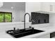 Close-up on sink featuring stylish faucet and hexagon backsplash at 111 Main St, Windermere, FL 34786