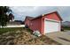 View of the two-car garage and side yard showcasing the home's exterior and outdoor space at 113 Kaigen Ct, Haines City, FL 33844