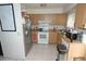 Functional kitchen with stainless steel refrigerator, white appliances, and light wood cabinets at 11418 Ashboro Dr, Orlando, FL 32837