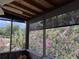 Relaxing screened porch with a wood ceiling provides stunning views of lush landscaping and beautiful flowering trees at 1292 Nadine Dr, Deltona, FL 32738