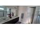 Bright bathroom with double sinks, a large mirror, and a glass-enclosed shower at 1544 Nassau Point Trl, Kissimmee, FL 34747