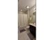 Full bathroom featuring tile flooring, shower with white curtain, and dark cabinets at 1544 Nassau Point Trl, Kissimmee, FL 34747