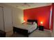Cozy bedroom featuring a red accent wall, carpet, and ceiling fan at 1544 Nassau Point Trl, Kissimmee, FL 34747